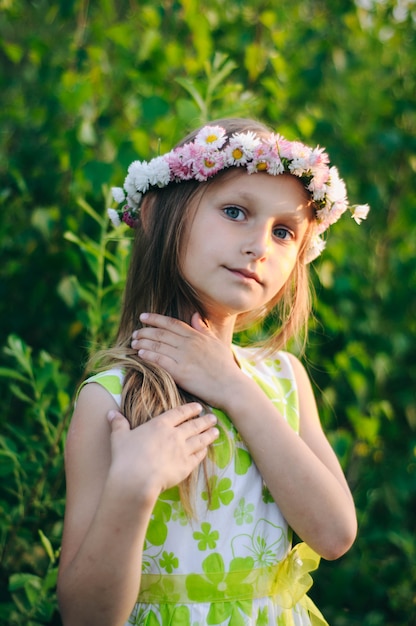 Mädchen mit langen Haaren und einem Blumenkranz auf dem Kopf