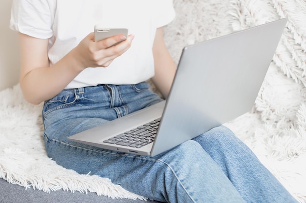 Mädchen mit Laptop zu Hause auf der Couch