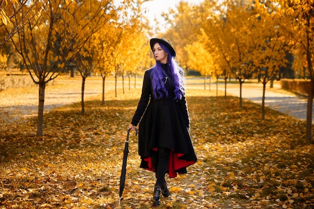 Mädchen mit lila Haaren im Herbst im Park