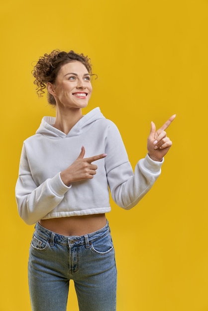 Mädchen mit lockigem Haar, das mit den Fingern zeigt