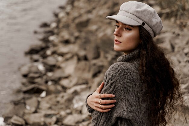 Mädchen mit lockigem haar neben see im herbst