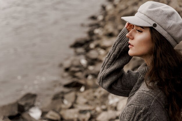 Mädchen mit lockigem Haar neben See im Herbst