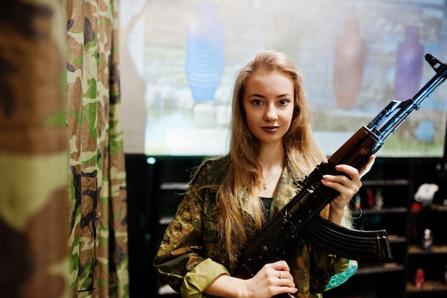 Foto mädchen mit maschinengewehr an den händen auf schießstand