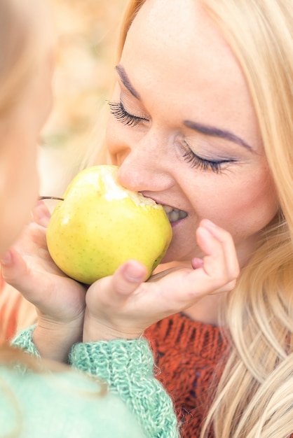 Foto mädchen mit mutter, die apfel isst