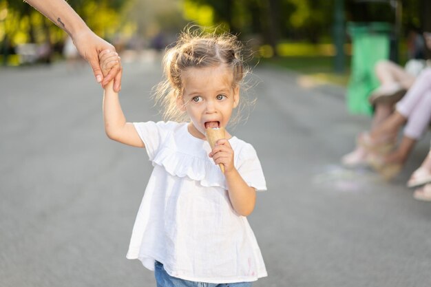 Foto mädchen mit mutter isst eis auf der straße