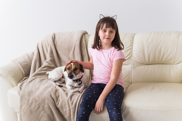 Mädchen mit niedlichem Hund Jack Russell Terrier auf der Couch