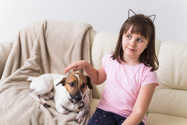 Mädchen mit niedlichem Hund Jack Russell Terrier auf der Couch