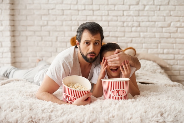 Mädchen mit Papa Watch Scary Film und Popcorn essen.