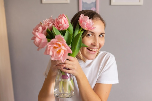 Mädchen mit rosa Tulpen in einer Glasvase 8. März Valentinstag Geburtstag Frau Datum