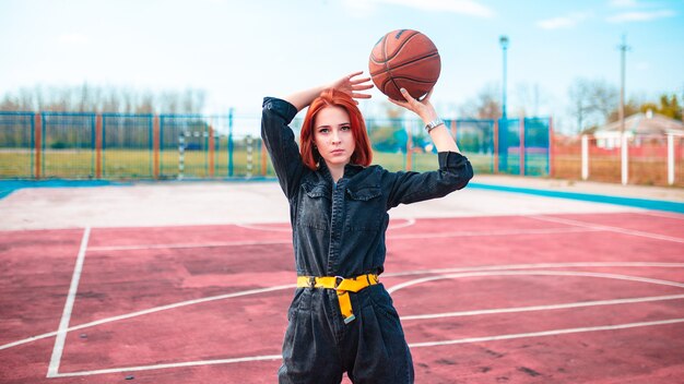 Mädchen mit roten Haaren am Basketballplatz