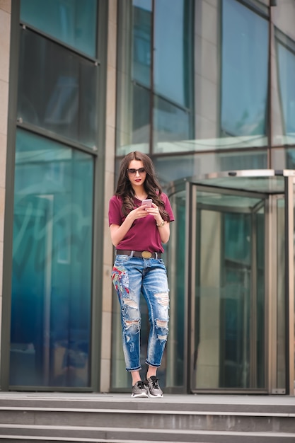 Mädchen mit Sonnenbrille mit Handy im Freien