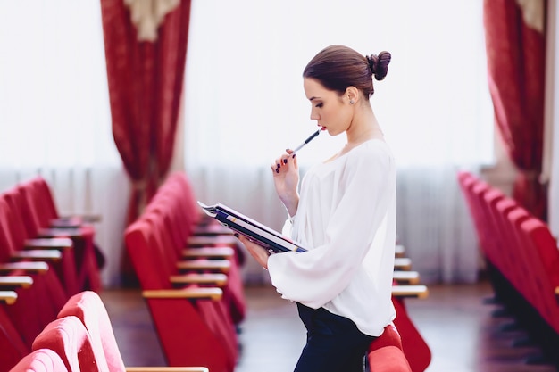 Mädchen mit Stift in der Hand überwacht Dokumente