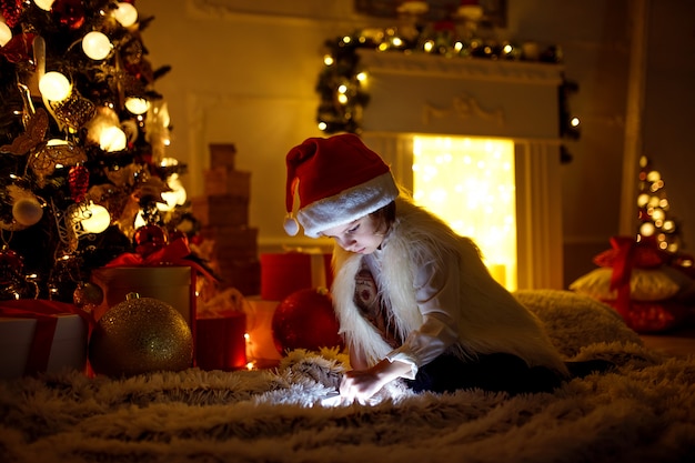 Mädchen mit Tablette nahe Weihnachtsbaum