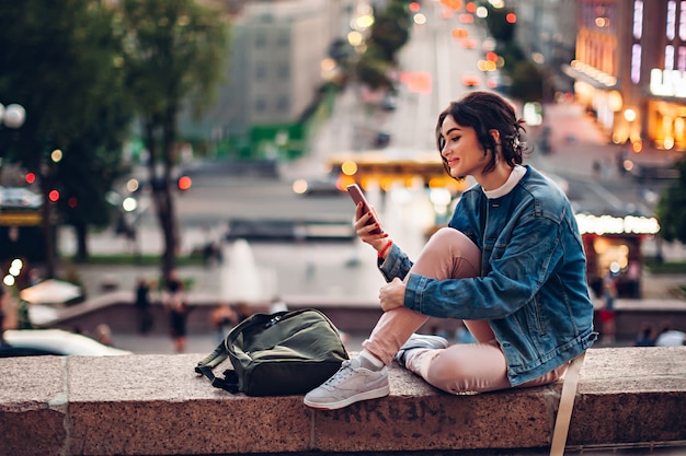 Mädchen mit Telefon in Straßenlaternen