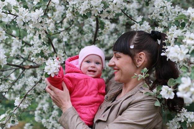 Mädchen mit Tochter in einem Frühlingsapfelblumengarten