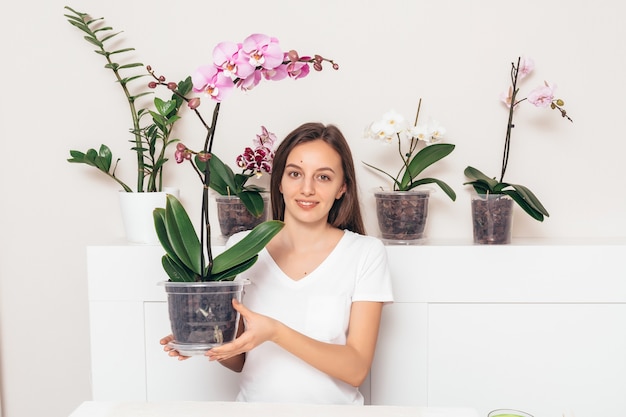 Mädchen mit Töpfen von Orchideen hinter