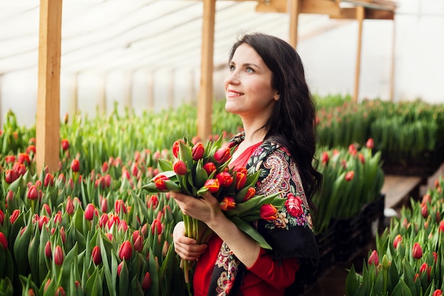 Mädchen mit Tulpen in einem Gewächshaus gewachsen.