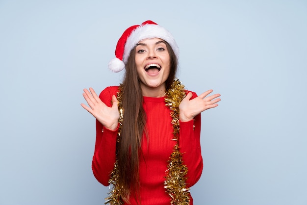 Mädchen mit Weihnachtshut über getrenntem Blau