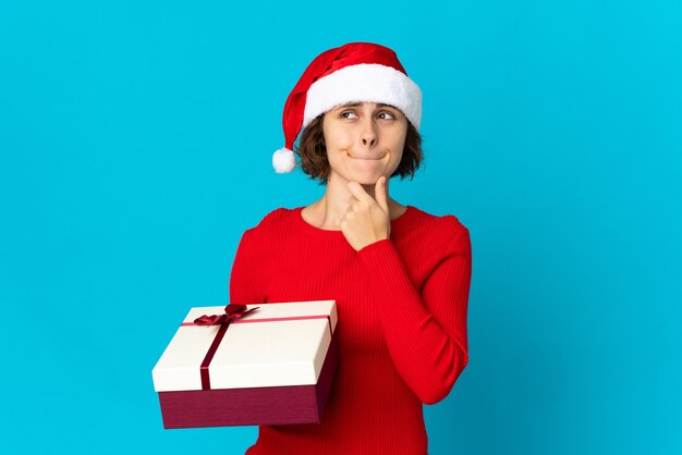 Mädchen mit Weihnachtsmütze auf einem blauen Hintergrund