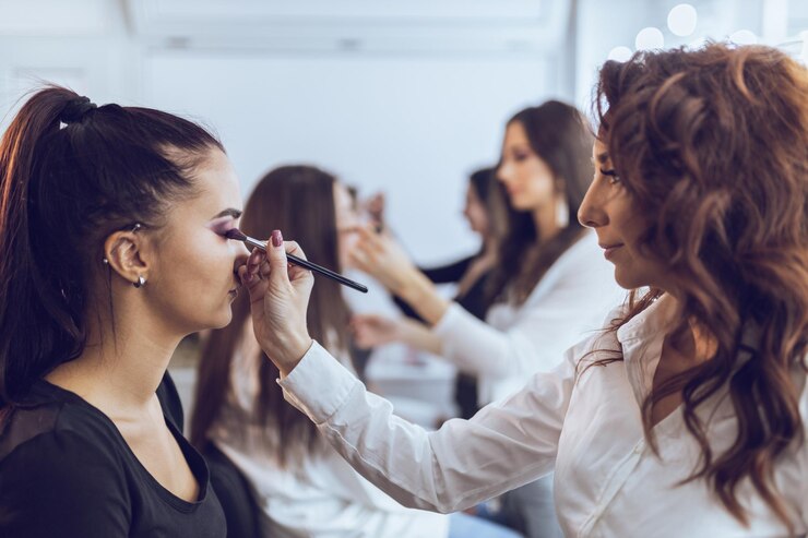 Foto mädchen nehmen an der make-up-meisterklasse teil. sie trainieren am model, wie man sich perfekt schminkt.