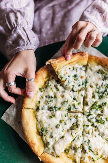 Mädchen nimmt ein Stück vegetarische Pizza