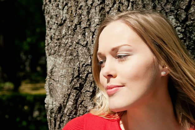 Mädchen posiert mit einem Baum