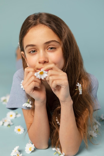 Mädchen posiert mit Gänseblümchen voller Schuss