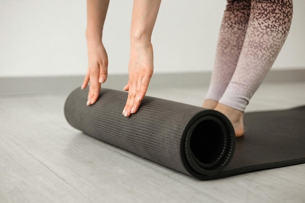 Mädchen rollt eine Yogamatte aus