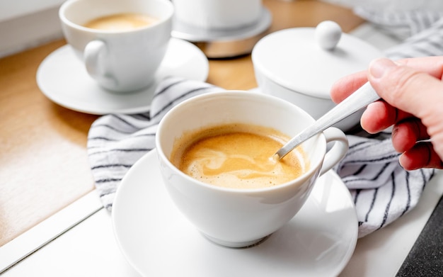 Mädchen rührt Zucker in einer Tasse Kaffee