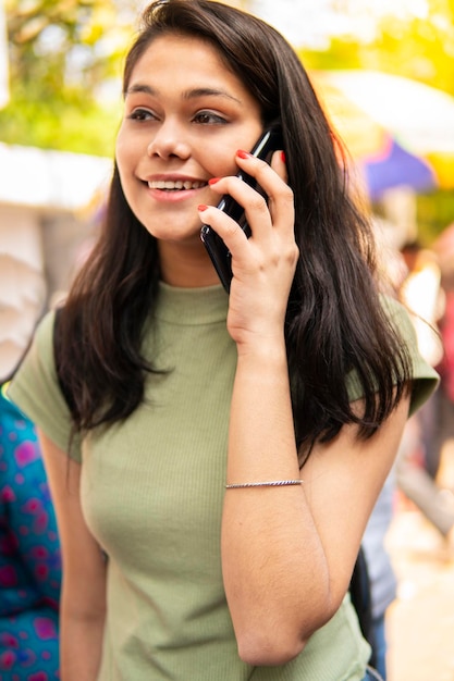 Mädchen schaut weg, während sie im Telefon in der Stadt spricht