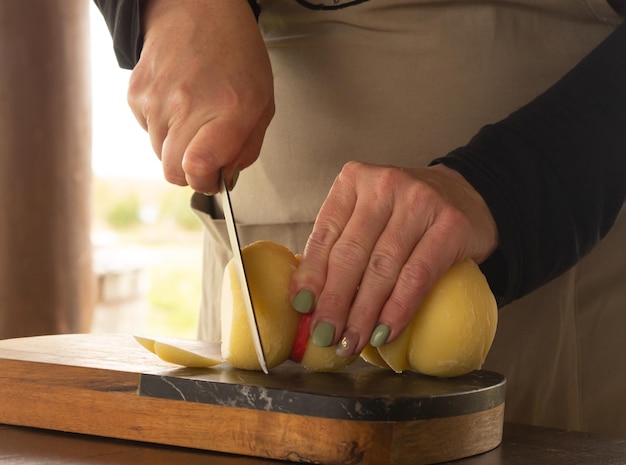 Mädchen schneidet Käse mit einem Messer