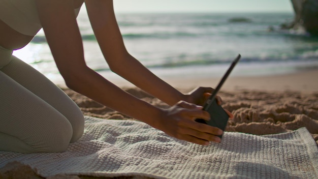 Mädchen setzen Tablette Yogamatte liegend Sandstrand hautnah Frau bereitet Training vor