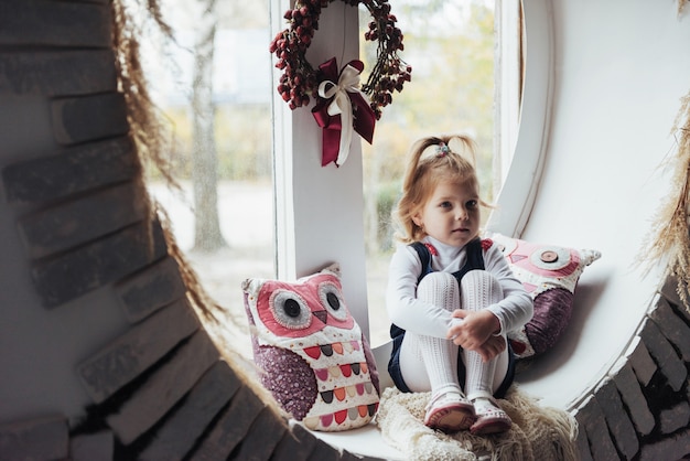 Mädchen sitzt am Fenster