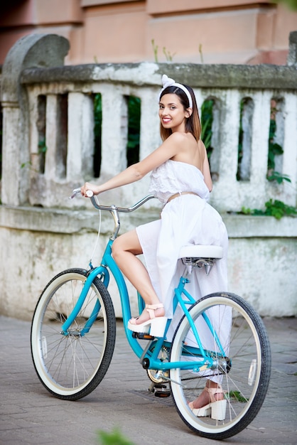 Mädchen sitzt auf einem Retro-Fahrrad im Freien