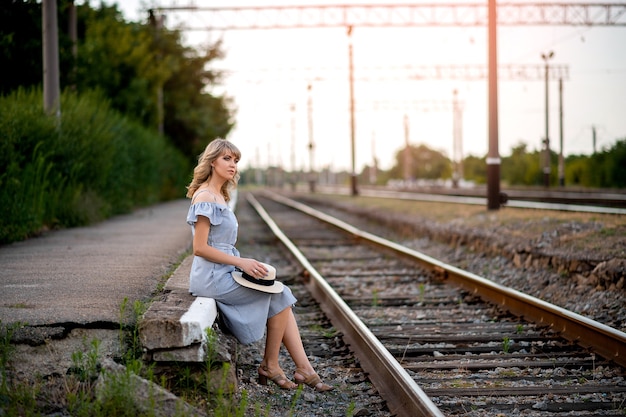 Mädchen sitzt auf Eisenbahnschienen