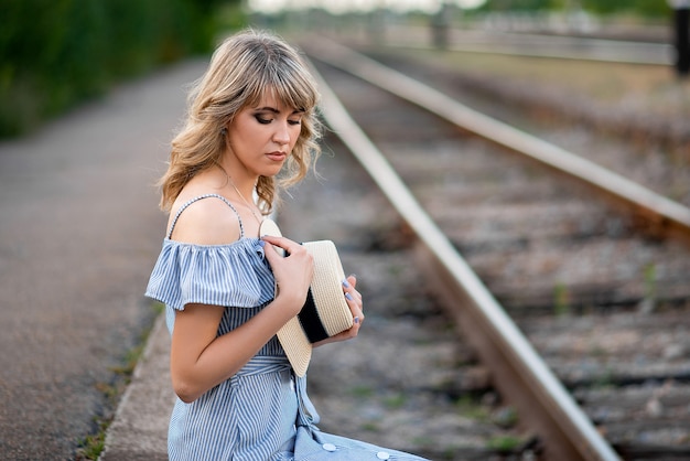 Mädchen sitzt auf Eisenbahnschienen