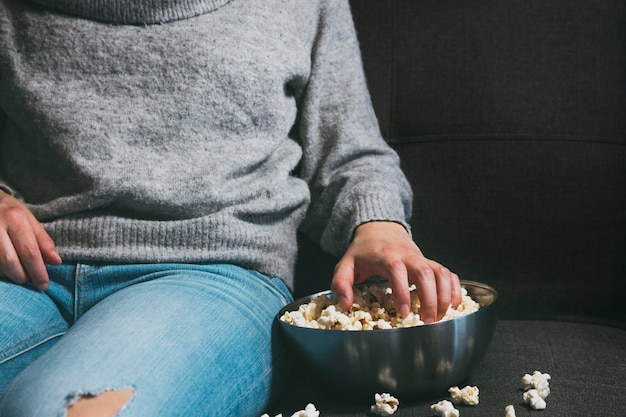 Mädchen sitzt, isst Popcorn und sieht sich einen Film an