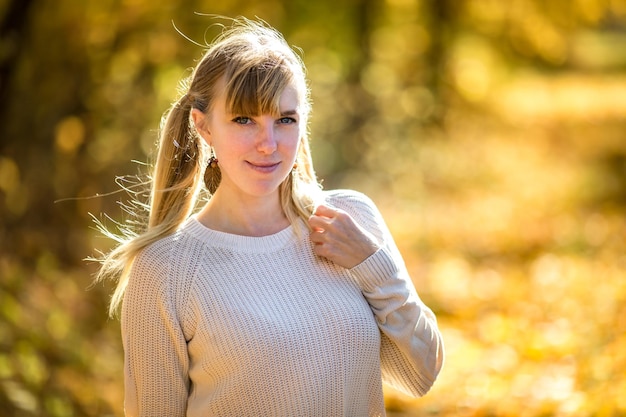 Mädchen sitzt und entspannt sich auf dem Boden im Herbstwald