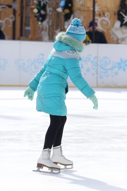 Mädchen skatet auf der Eisbahn