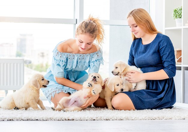 Mädchen spielen mit Retriever Welpen