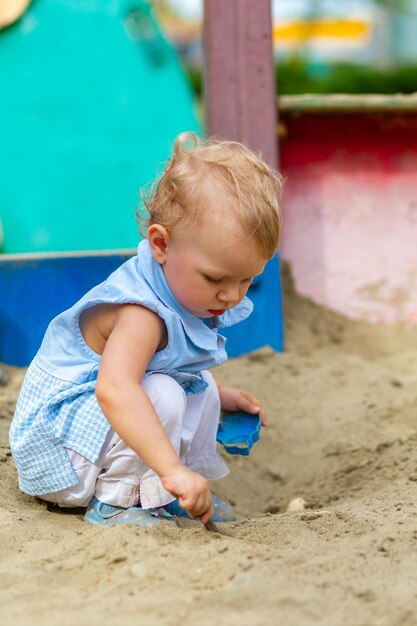 Mädchen spielen mit Spielzeug im Sandkasten im Hof