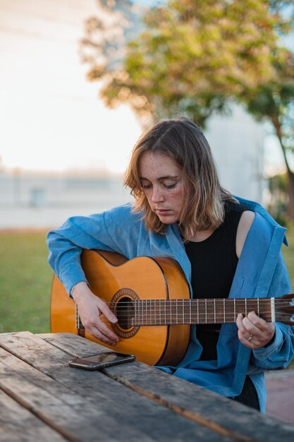 Mädchen spielt Gitarre am Picknicktisch