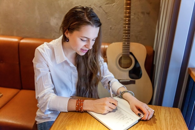 Mädchen spielt Gitarre im Café