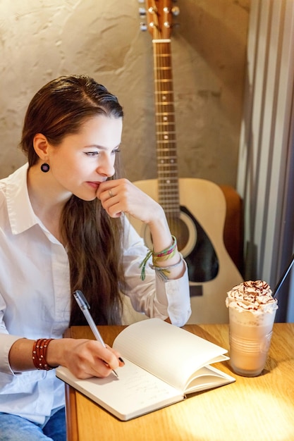 Mädchen spielt Gitarre im Café