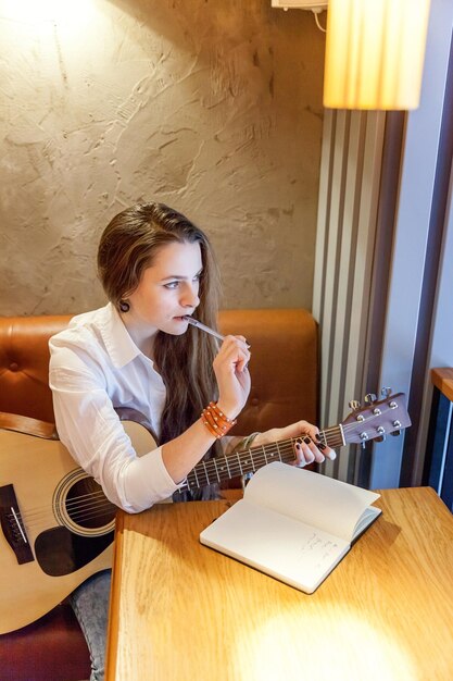 Mädchen spielt Gitarre im Café