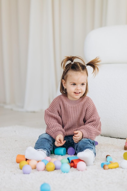 Foto mädchen spielt spielzeug im wohnzimmer montessori holzspielzeug gefaltete pyramide kreis dreieck rechteck holzelemente von children39s spielzeug farbiges spielzeug blau gelb rot grün