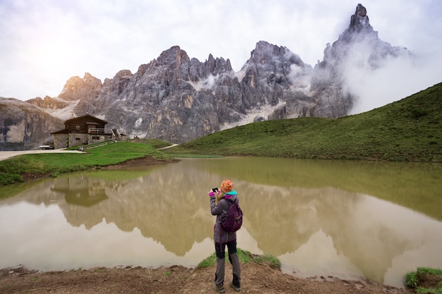 Mädchen steht am See und macht ein Foto