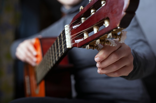 Mädchen stimmt eine akustische Gitarrennahaufnahme ab. ein Musikinstrument spielen.