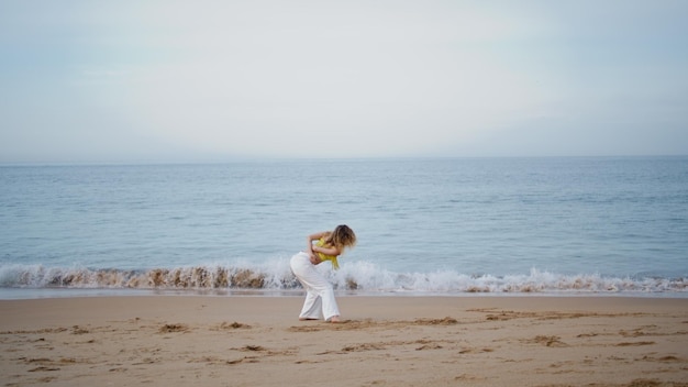Mädchen tanzt Improvisationen am Sandstrand, Frau tanzt als Choreografin
