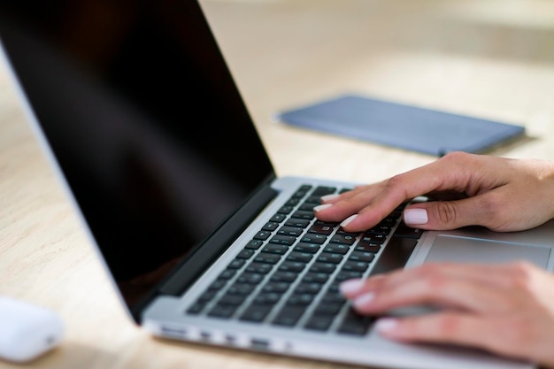 Mädchen tippt auf Laptop in der Hotellobby, Fernarbeitskonzept aus nächster Nähe